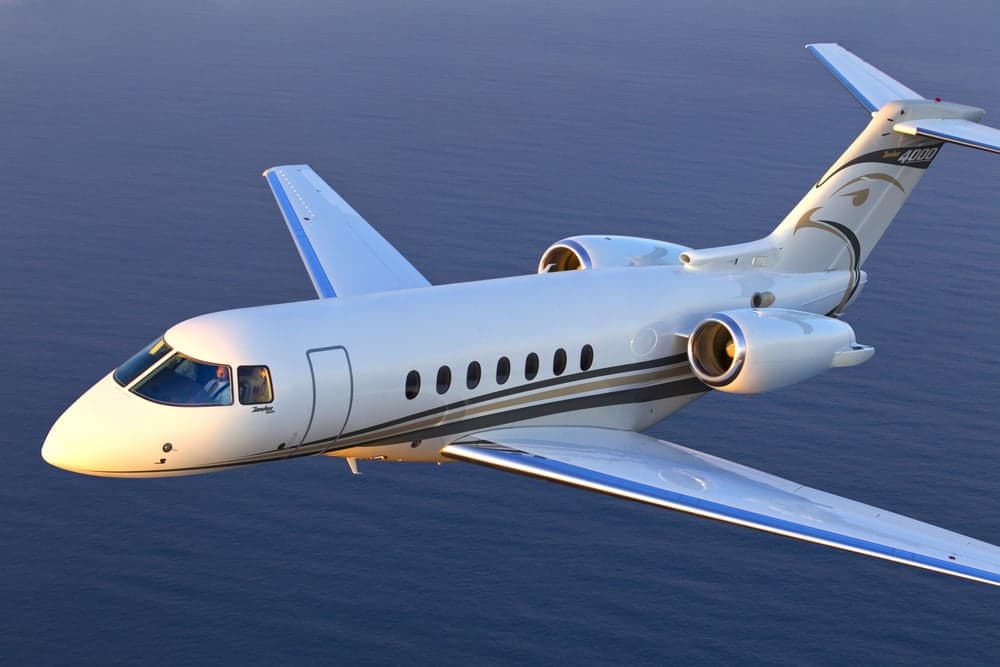A Hawker 4000 in flight over the ocean.