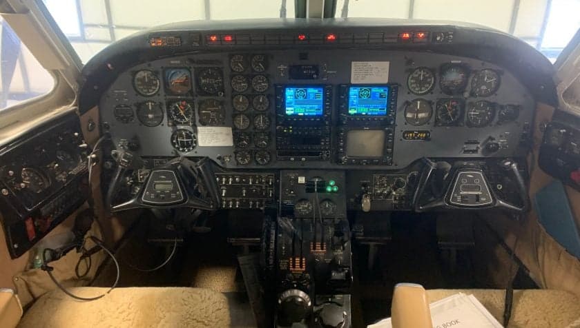 Wide view of the aircraft's cockpit, showing the instrument panel and pilot seats.