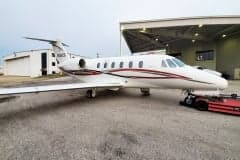 Side view of a Cessna Citation CJ3+ with red and black stripes.