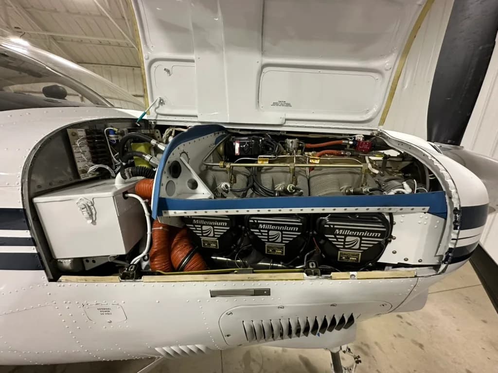 The engine compartment of the Beechcraft Bonanza with the cowling open.