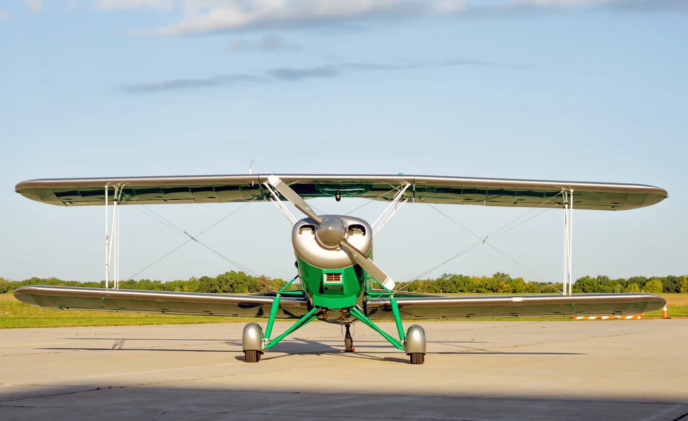 Front view of the biplane with green and silver paint scheme.
