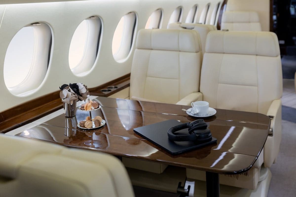 View of the aircraft interior with cream-colored seats and a table set with snacks.