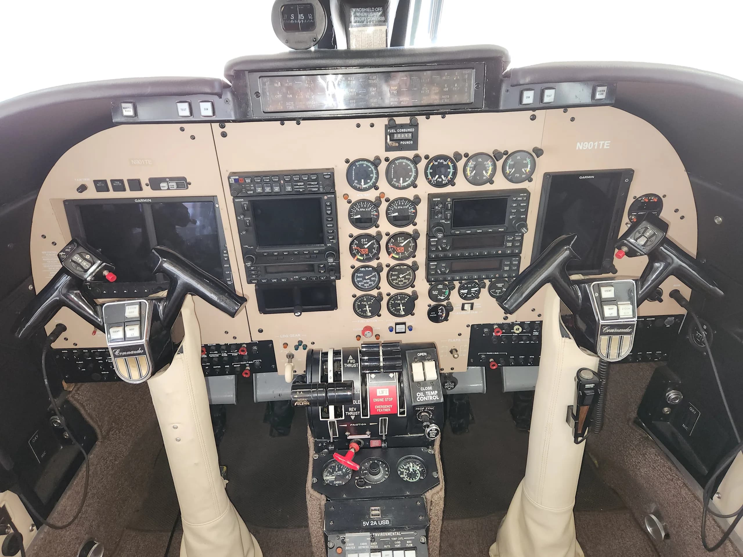 The cockpit of the Commando aircraft features a tan instrument panel and dual yokes.