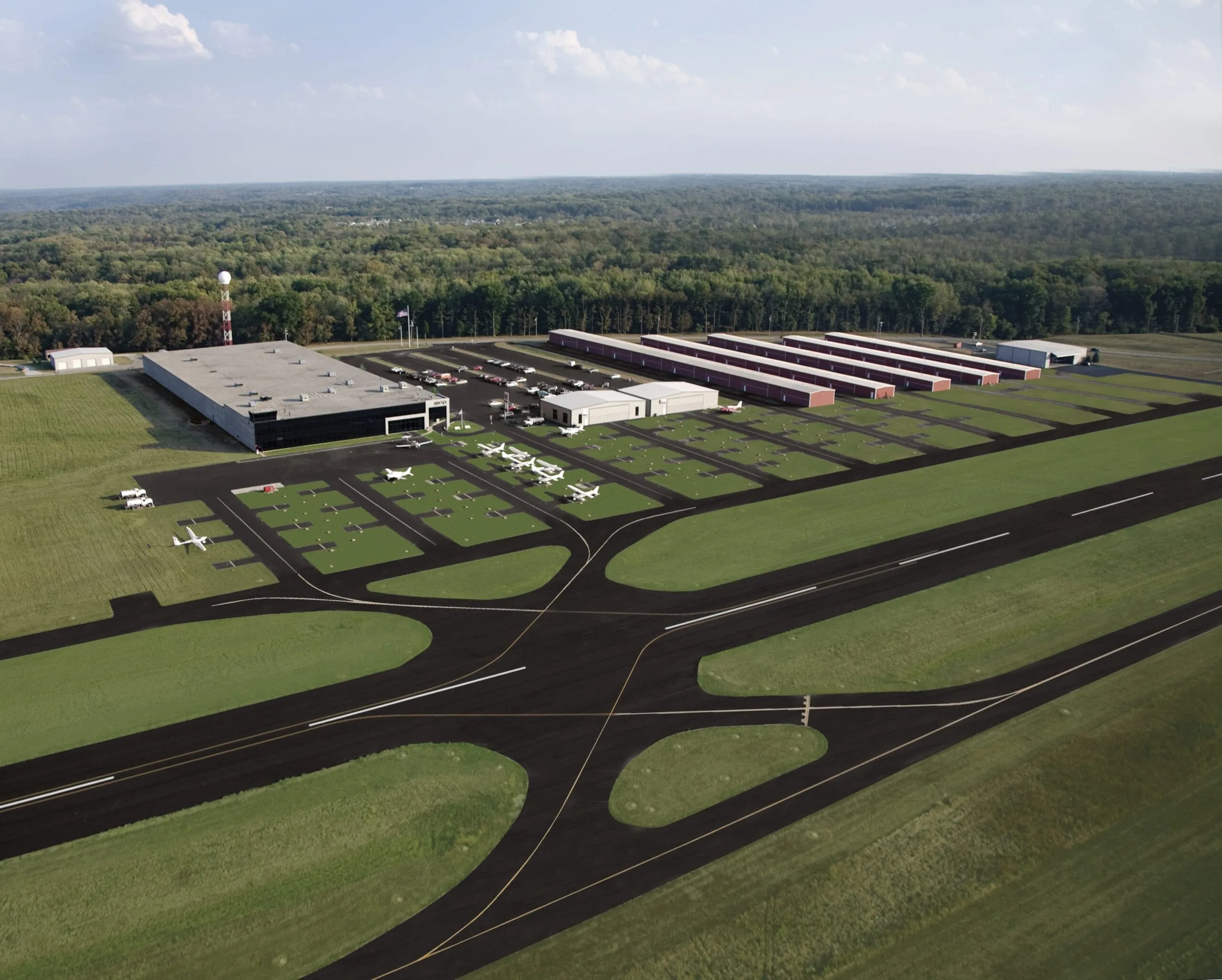 Aerial view of an airport with multiple hangars and aircraft parked on the tarmac.