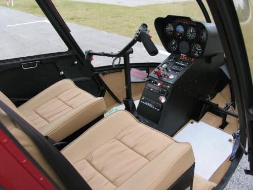 View of the cockpit instrument panel and front seats inside the helicopter.