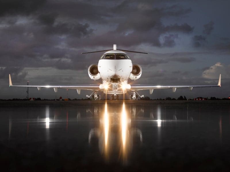 Front view of a Bombardier Challenger 350 aircraft with registration N310VZ parked on the tarmac at dusk.