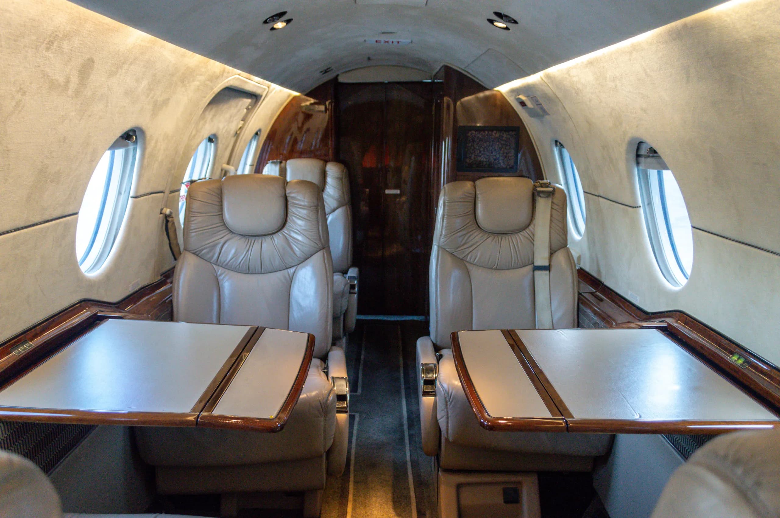 Interior view of the Learjet cabin showing the seating arrangement and tables.