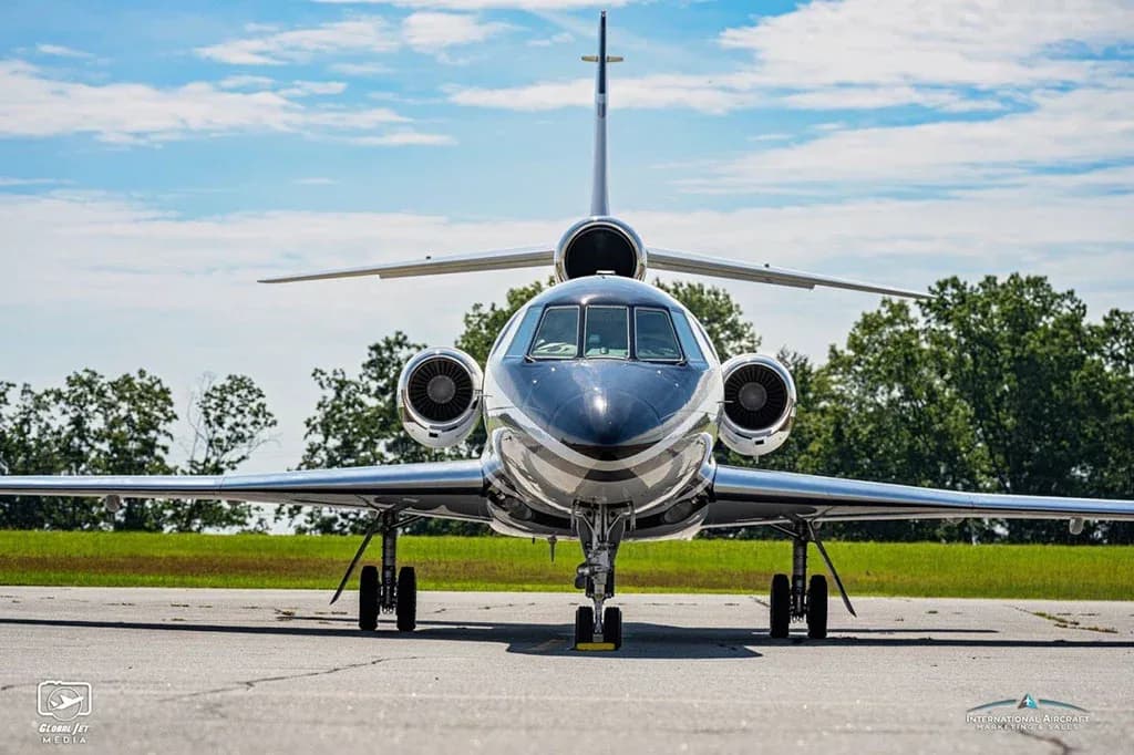A Dassault Falcon 900EX business jet, registration N86TN, parked on an airfield, viewed directly from the front.