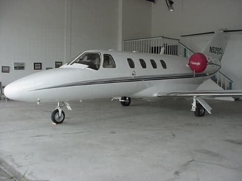 A Cessna CitationJet is parked inside a hangar.