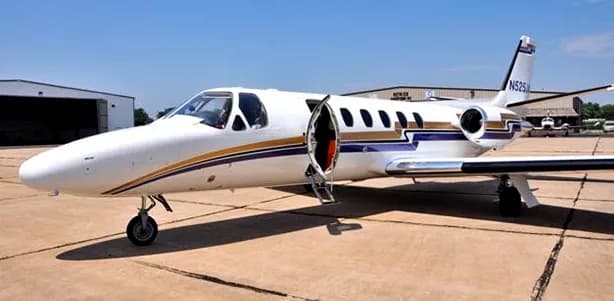 A Cessna Citation CJ1+ aircraft with its door open on the tarmac.