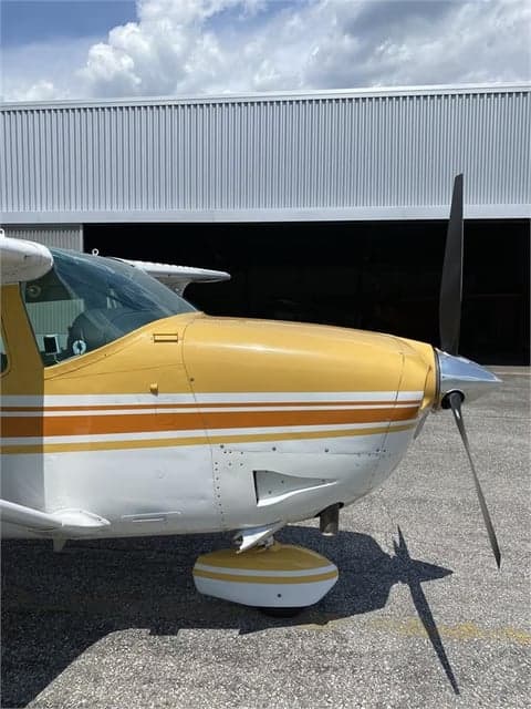 Close-up of the nose and propeller of a Cessna 210 Centurion aircraft.