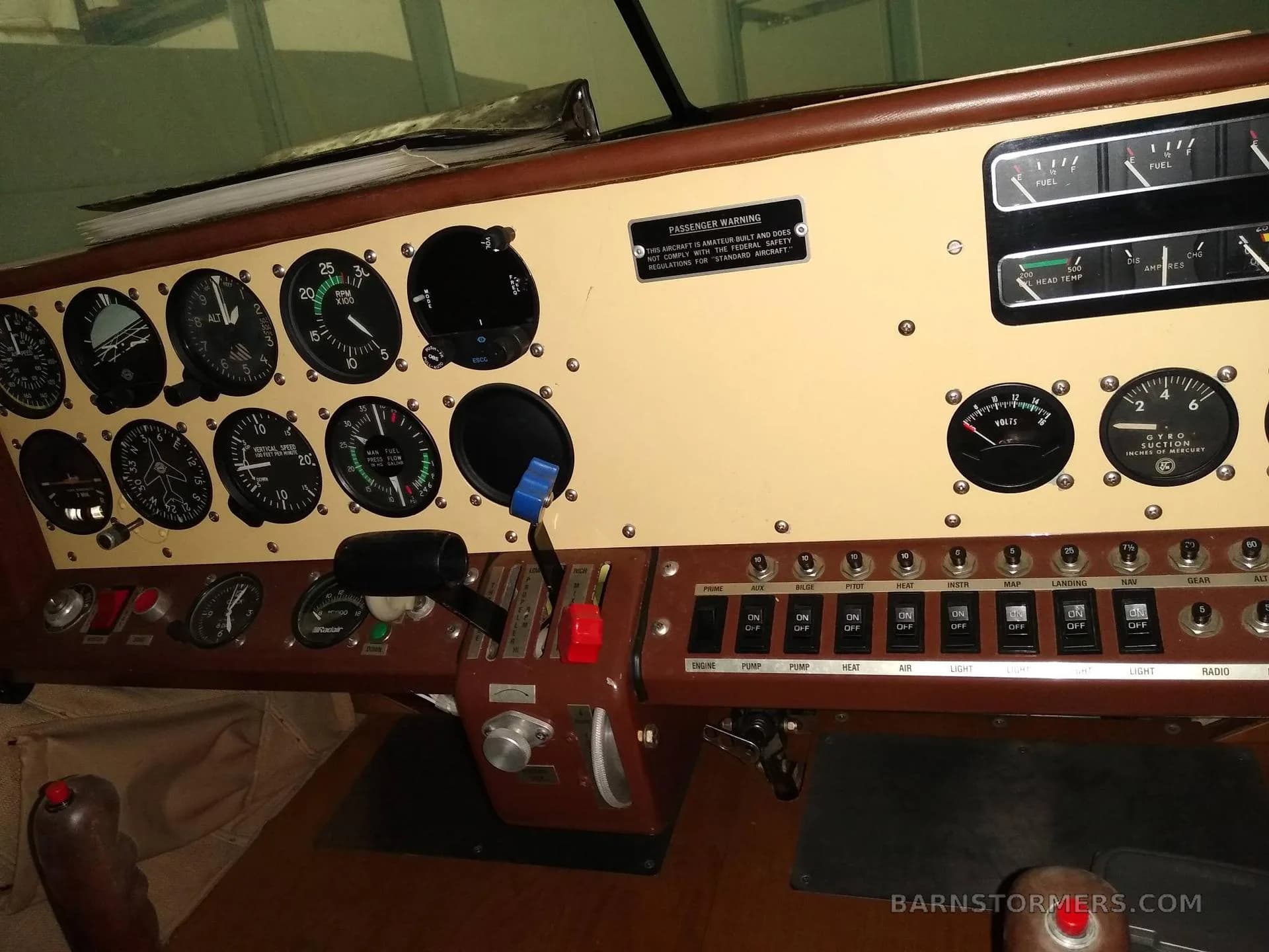 The brown and beige instrument panel of an aircraft, featuring various gauges, switches, and controls.