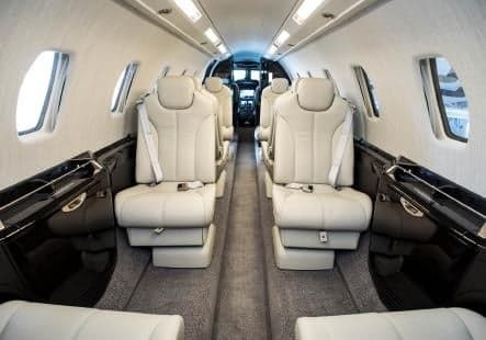View of the aircraft cabin with white leather seats.