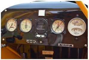 Interior compartment of the yellow Piper Cub with documents and equipment.