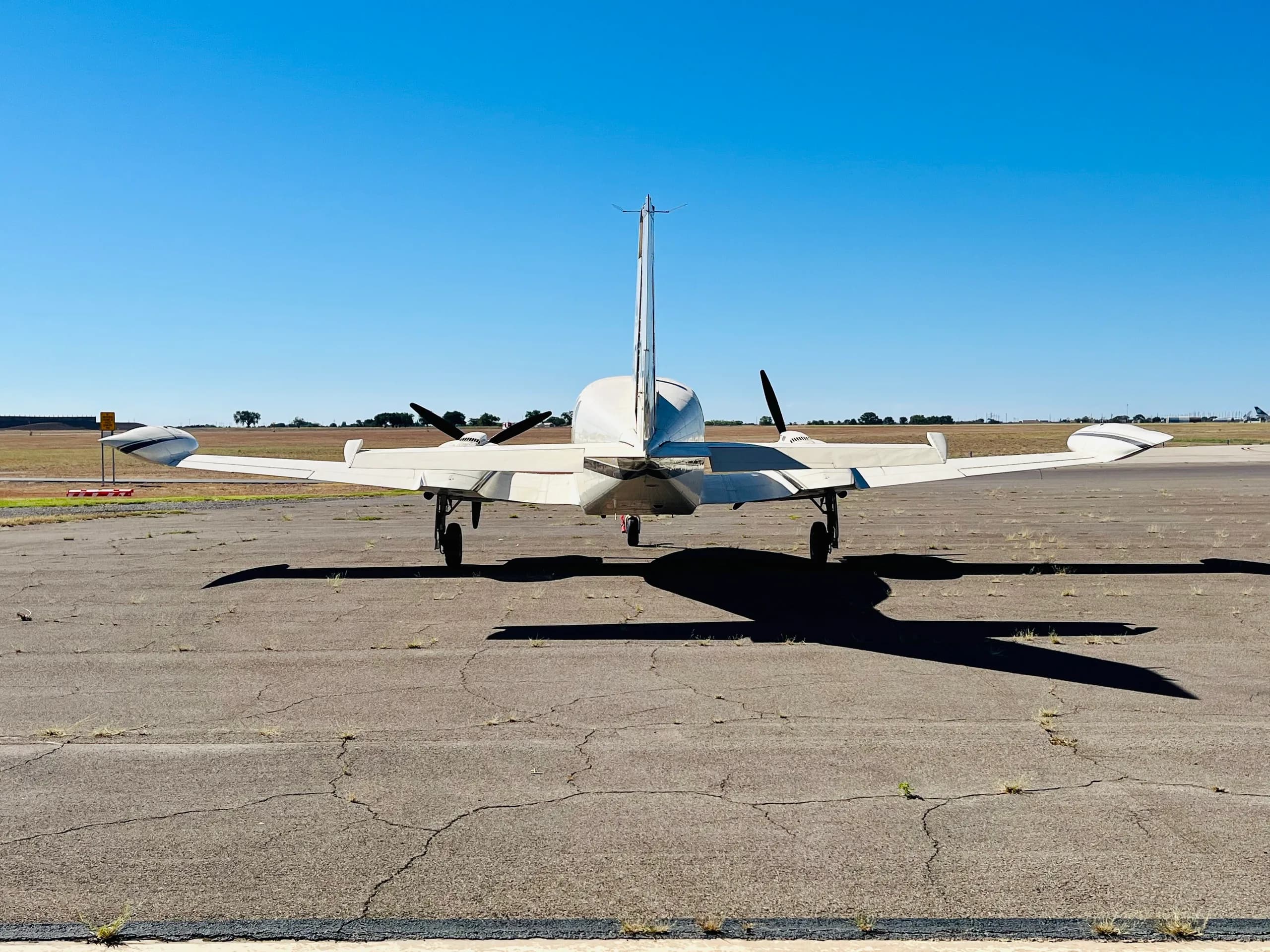 A rear view of a white Cessna 421 Golden Eagle (N4070L) parked on an airfield, showing its twin engines and tail.