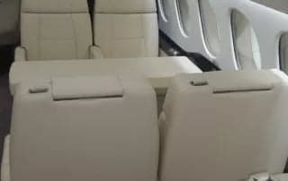 Interior view of the aircraft cabin with cream-colored leather seats.