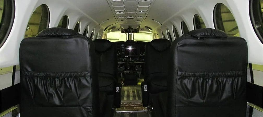 The interior cabin of a King Air 350 with black leather seats.