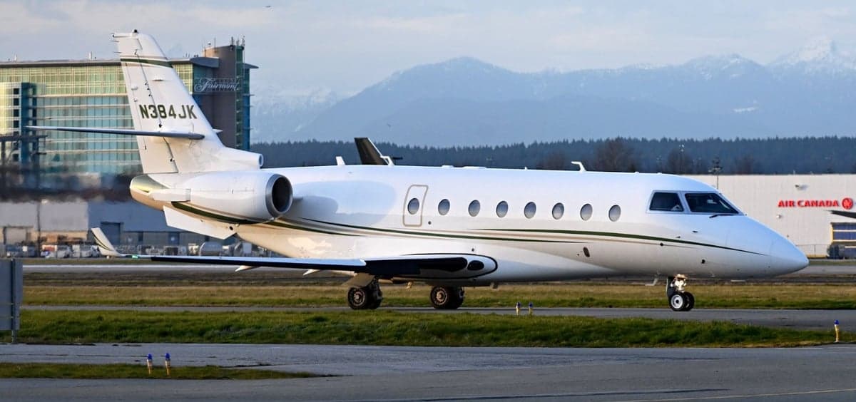 A white aircraft with tail number N384JK is parked on the tarmac.