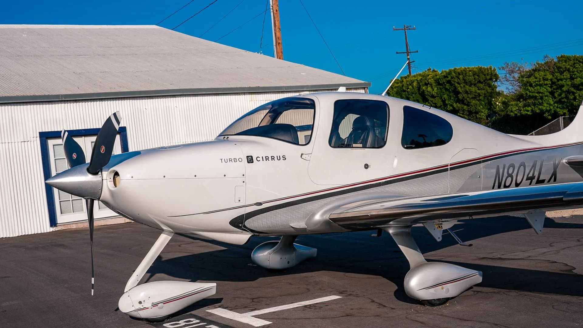 A close-up view of the front and side of a white and silver Cirrus SR22T aircraft N804LX.