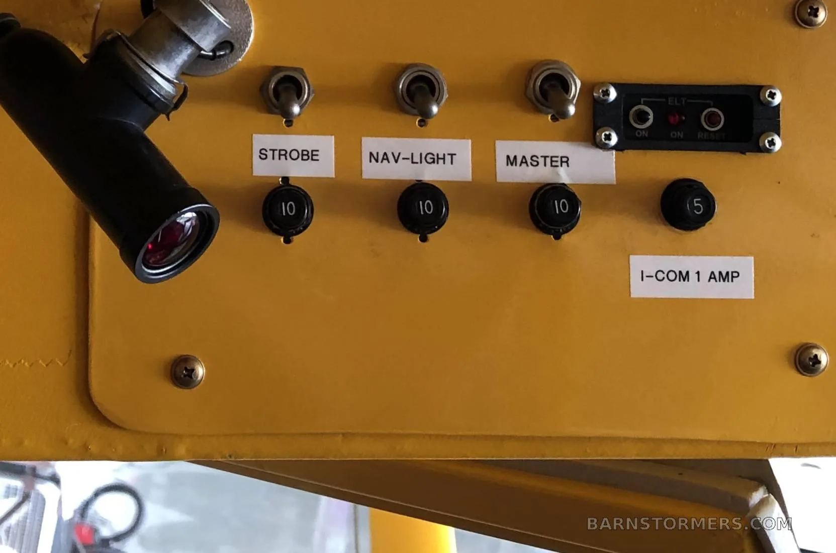 A close-up of an aircraft control panel with toggle switches for strobe, nav-light, and master, along with circuit breakers.