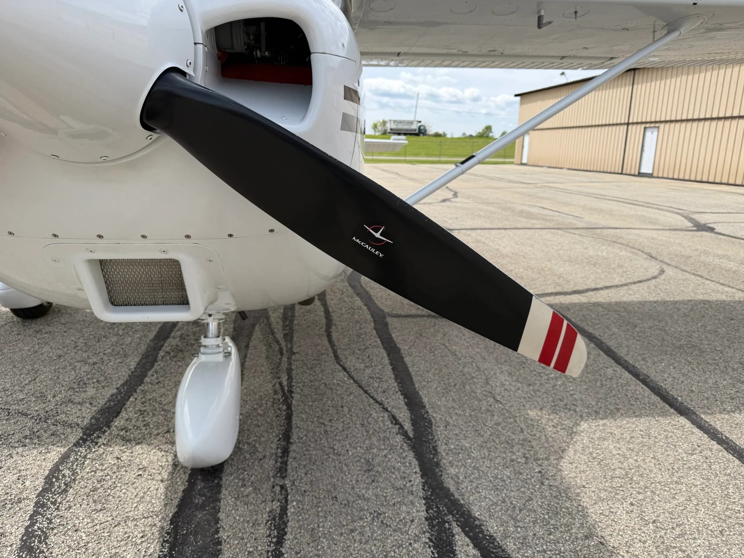 A close-up view of the aircraft's propeller and nose landing gear.