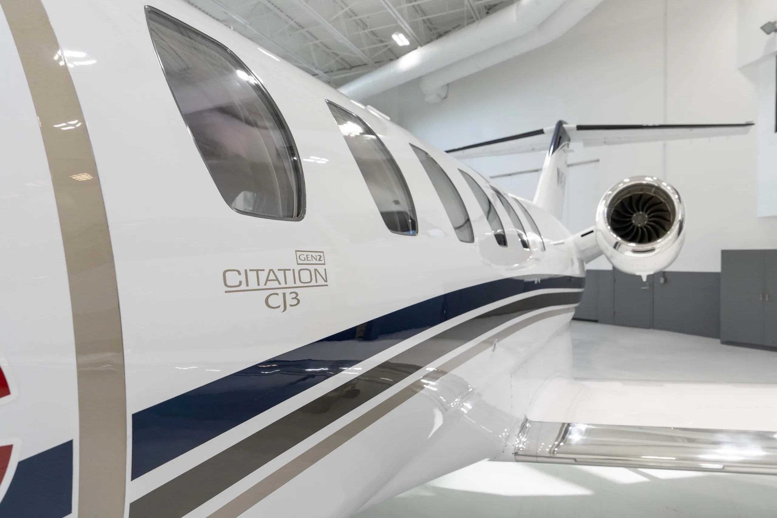A close-up view of the rear fuselage of a white Cessna Citation CJ3 Gen2 jet, showing the engine and 'CITATION CJ3 GEN2' text.