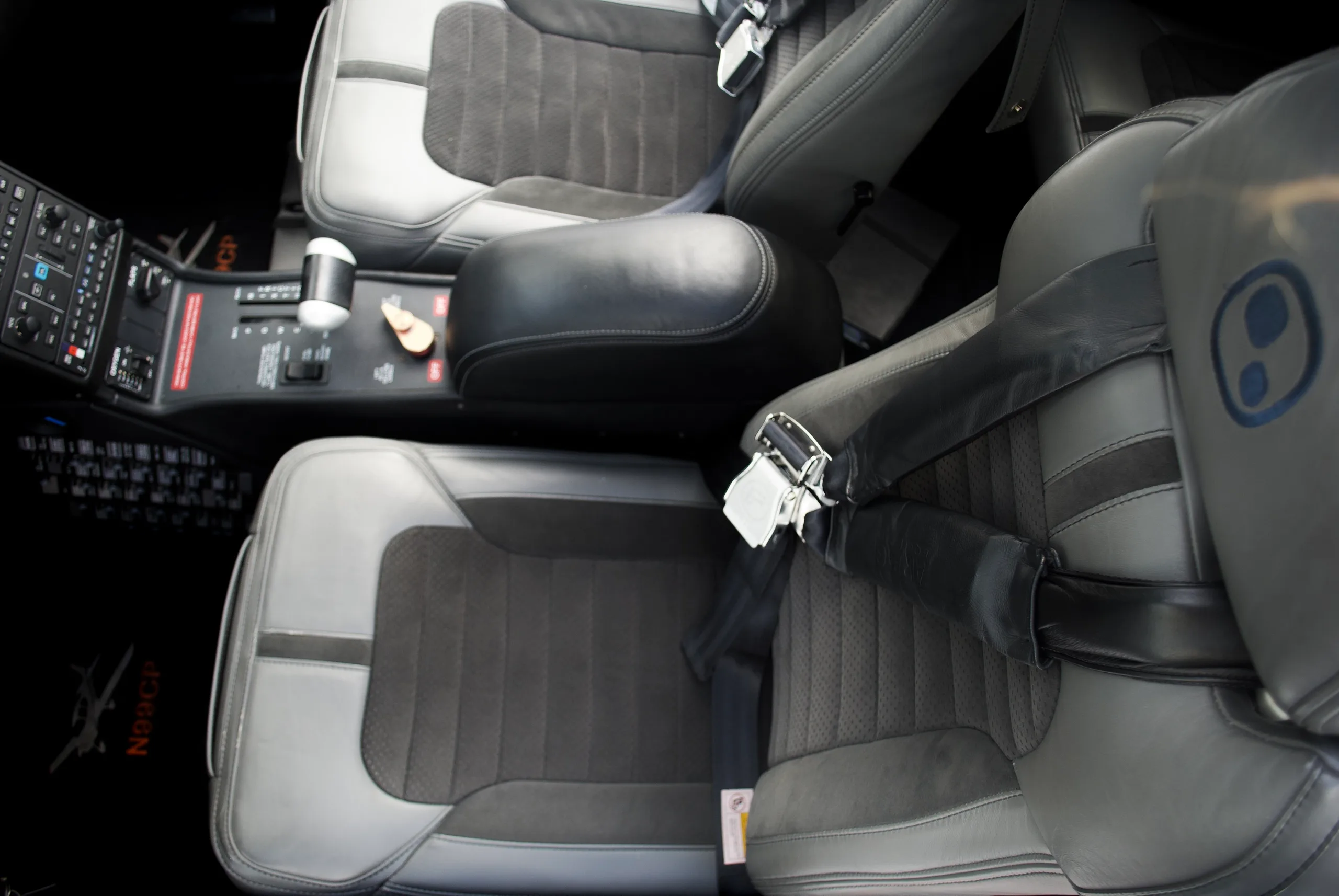A top-down view of the gray and black leather interior seats and center console of the Cirrus SR22T aircraft.