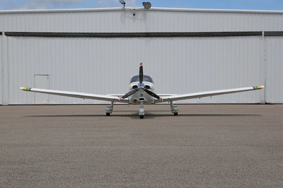 Front view of a white and green Piper Dakota aircraft on the tarmac.