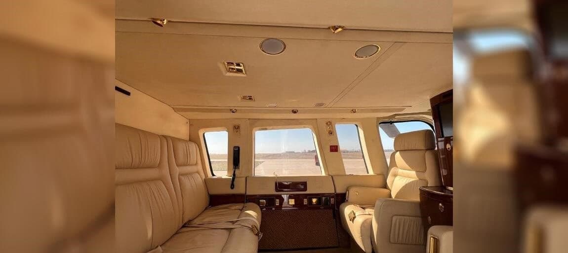 The helicopter's interior has cream-colored leather seats and a small entertainment system.