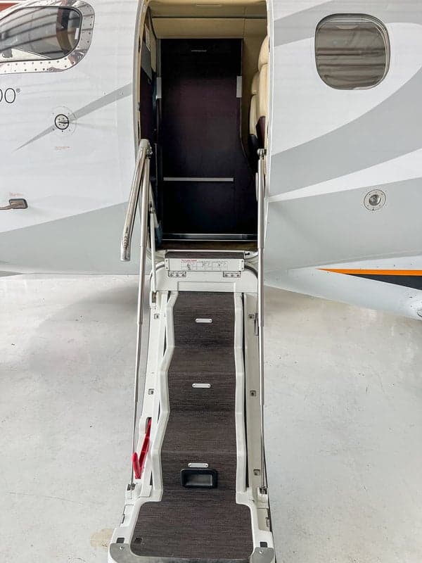 Close-up of the Phenom 100 aircraft's entry steps and doorway.
