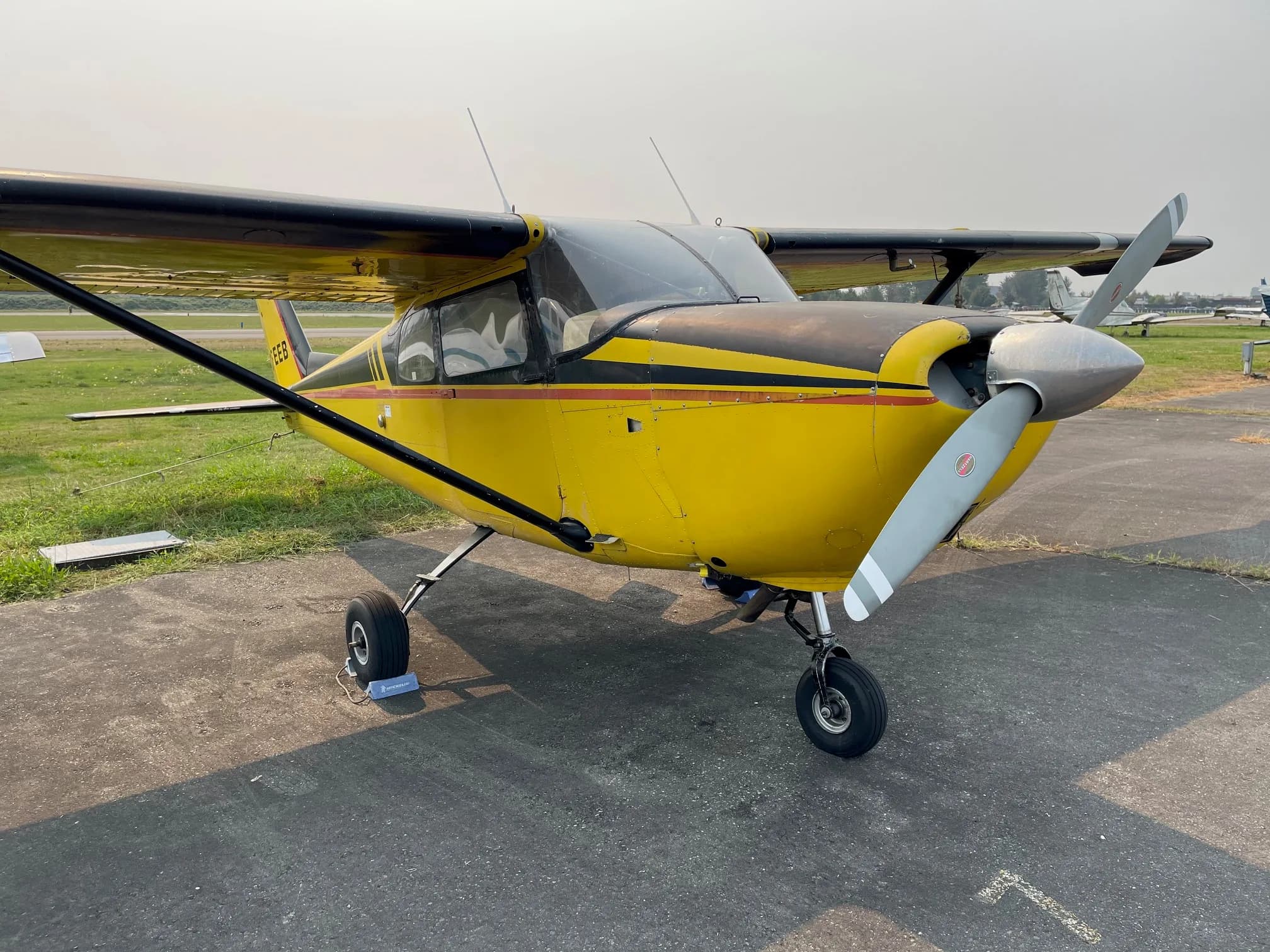 Front view of a yellow and black Cessna aircraft on the ground.
