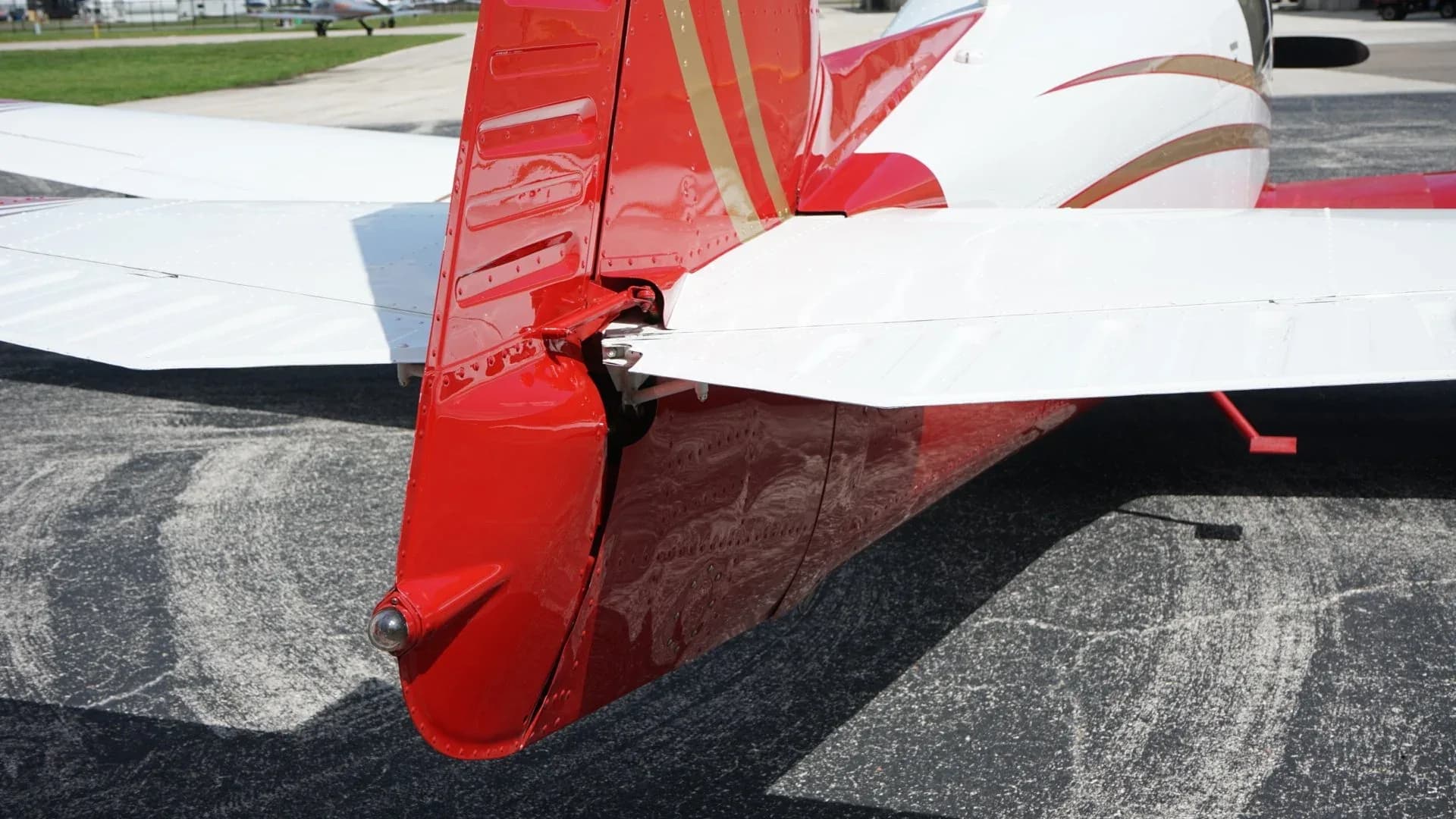A close-up of the red tail section and horizontal stabilizer of the aircraft, showing the N-number.
