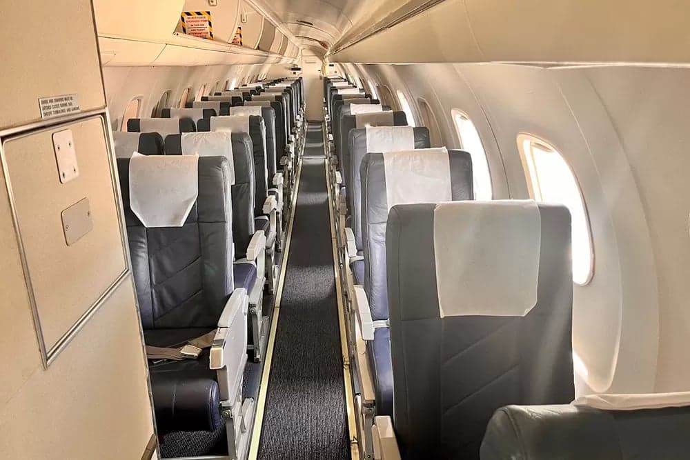 Aisle view of the aircraft's passenger cabin with rows of seats.
