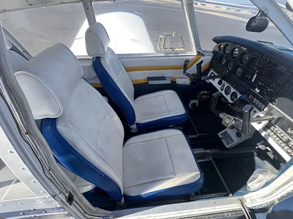 View of the cockpit and front white and blue seats of the aircraft.