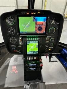The instrument panel of the Robinson R66 helicopter shows navigation displays.
