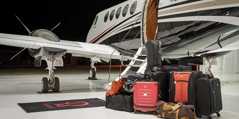 King Air 260 with luggage piled in front of the open door.