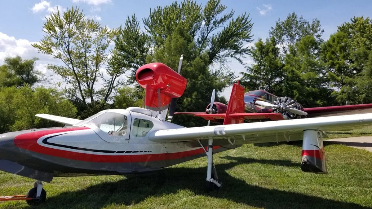 A Republic RC-3 Seabee aircraft with a red and white paint scheme is parked on the grass.