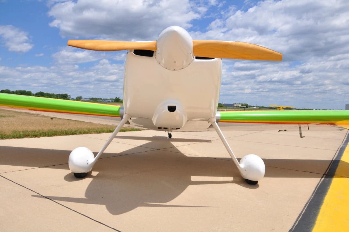 Front view of a white and colorful experimental aircraft on the tarmac.