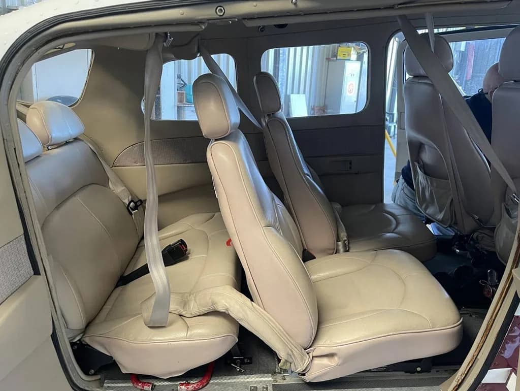 A view of the beige leather aircraft cabin interior, showing multiple rows of seats.