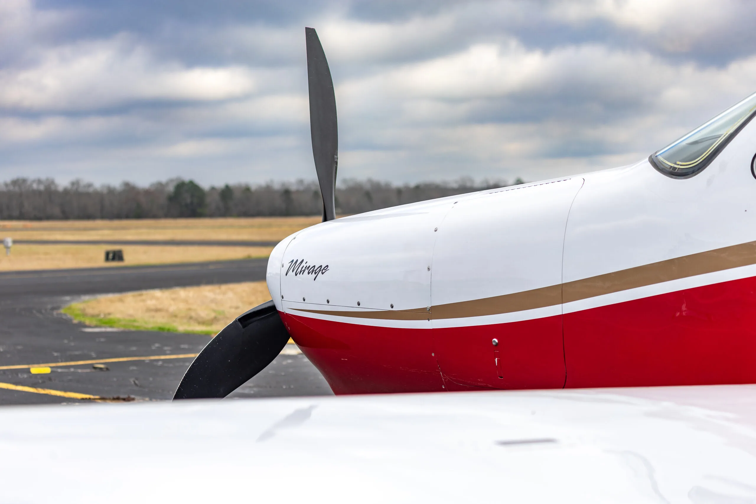 Close-up of the nose of the Piper Mirage, showing the propeller and 'Mirage' logo.
