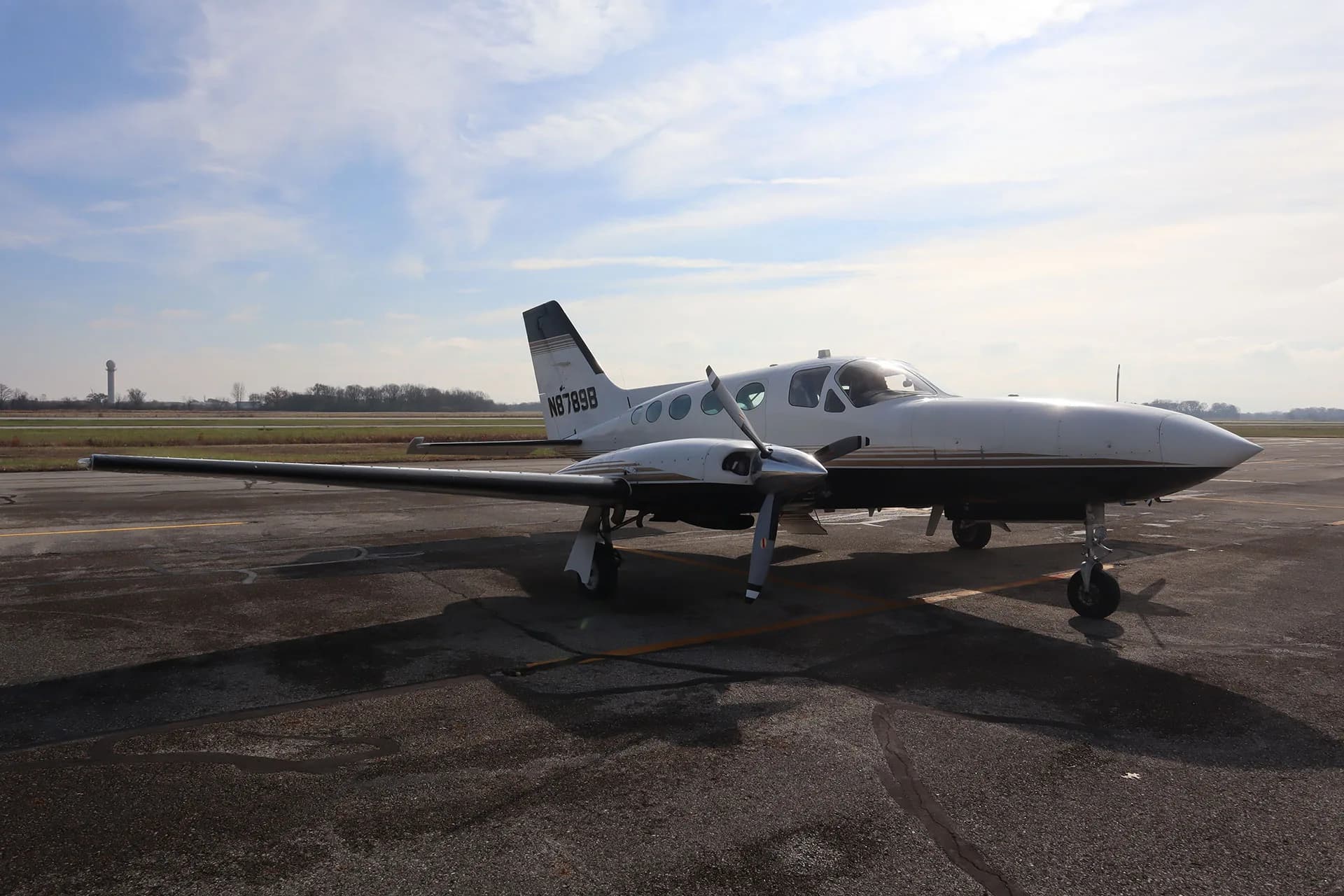 The N8789B aircraft is parked on the tarmac with a cloudy sky in the background.