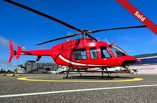 Red Bell 407 helicopter on the tarmac with a 'SOLD' banner.
