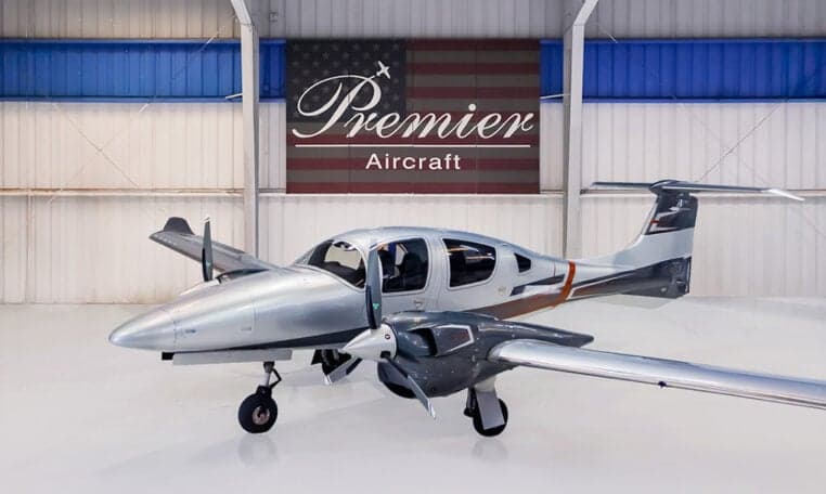 Diamond DA62 aircraft in a hangar with a silver and gray paint scheme.