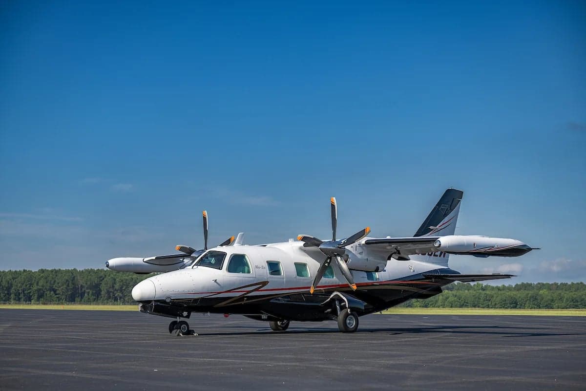 Front quarter view of the N33EW aircraft on the tarmac with a black, white, and gold paint scheme.