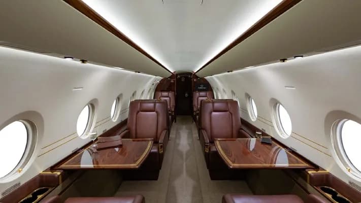 Cabin of a Gulfstream G280 with leather seats and wood tables.
