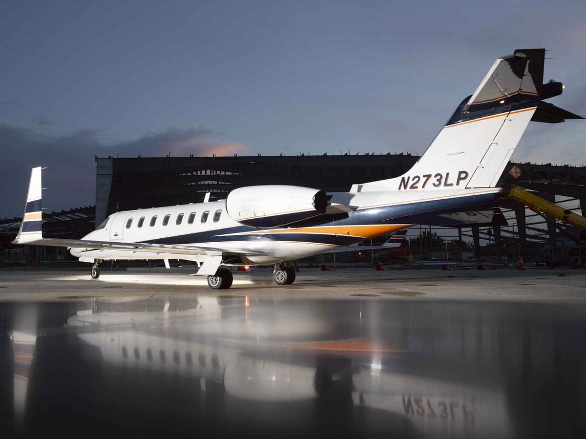 Rear side view of the N273LP aircraft on the ground with a reflective surface.