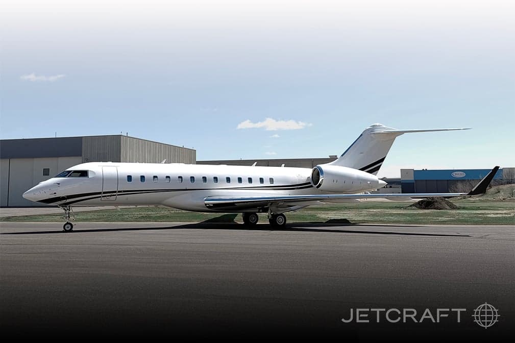 Side view of a white and black Bombardier Global Express on the tarmac.