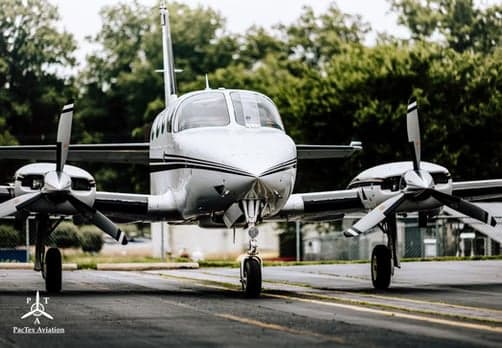 Front view of a twin-engine aircraft on the tarmac.