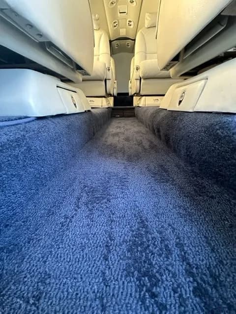View of the aircraft cabin aisle with blue carpet.