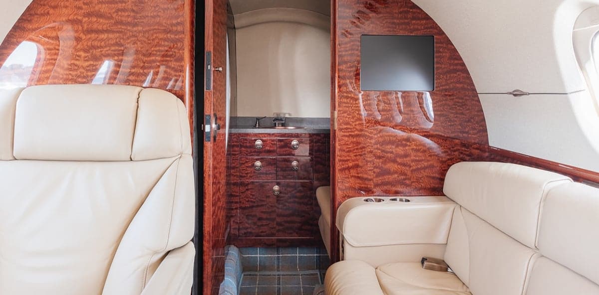 View of the aircraft's interior showing the lavatory and wood paneling.